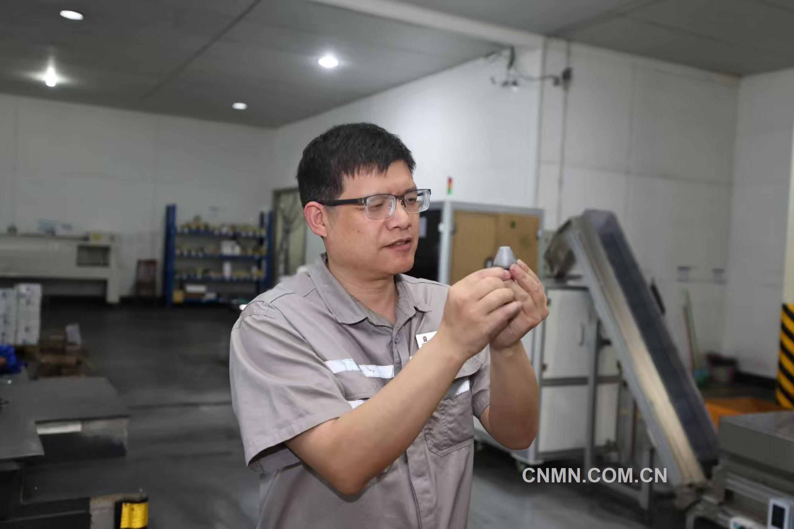 譚竹峰在對銑刨齒的表面質量進行檢查。